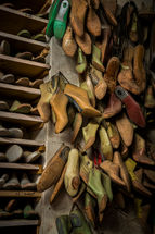 Wooden shoe lasts hanging on the wall of a traditional shoemaker's workshop in Tuscany, Italy, showcasing handcrafted leather shoe forms and authentic Italian craftsmanship.