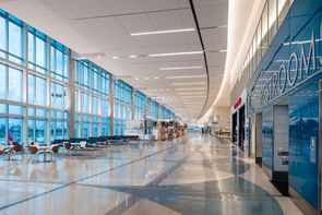 Interior of Fort Lauderdale-Hollywood International Airport in Fort Lauderdale, Florida, featuring a spacious terminal with floor-to-ceiling glass walls, polished floors, modern seating, and contemporary architectural design.