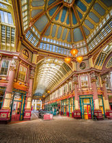 Historic Leadenhall Market in London, England, with Victorian architecture, colorful storefronts, cobblestone walkways, and an ornate glass ceiling.