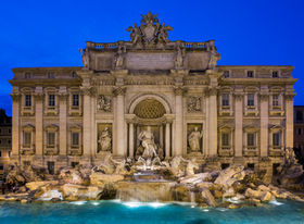 Trevi Fountain in Rome, Italy, photographed at twilight, featuring its grand Baroque façade, marble sculptures, cascading fountains, illuminated architecture, and a deep blue evening sky.