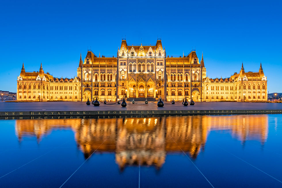 Budapest Parliament at twilight and reflecting in water.
