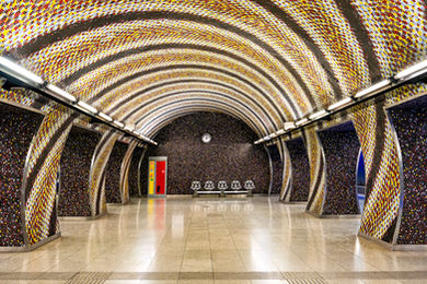 Modern Budapest Metro station featuring arched ceilings, colorful mosaic tile walls, and contemporary architectural design.