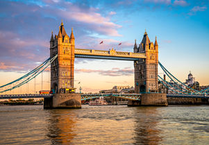 Tower Bridge illuminated at blue hour over the River Thames in London, England, with colorful evening skies and reflections on the water.
