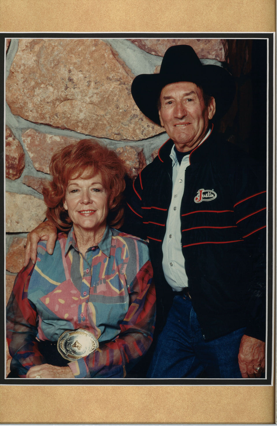 Smiling couple portrait: man in cowboy hat, woman in patterned blouse