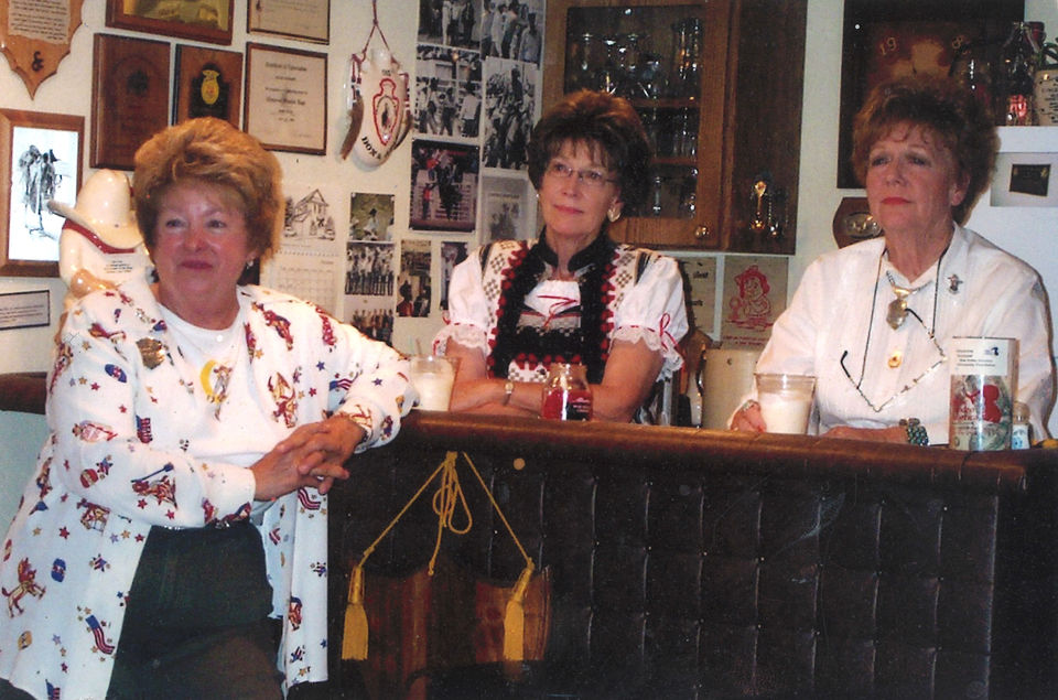 Three women at bar, awards on wall