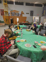 people sitting at round tables with green table cloths