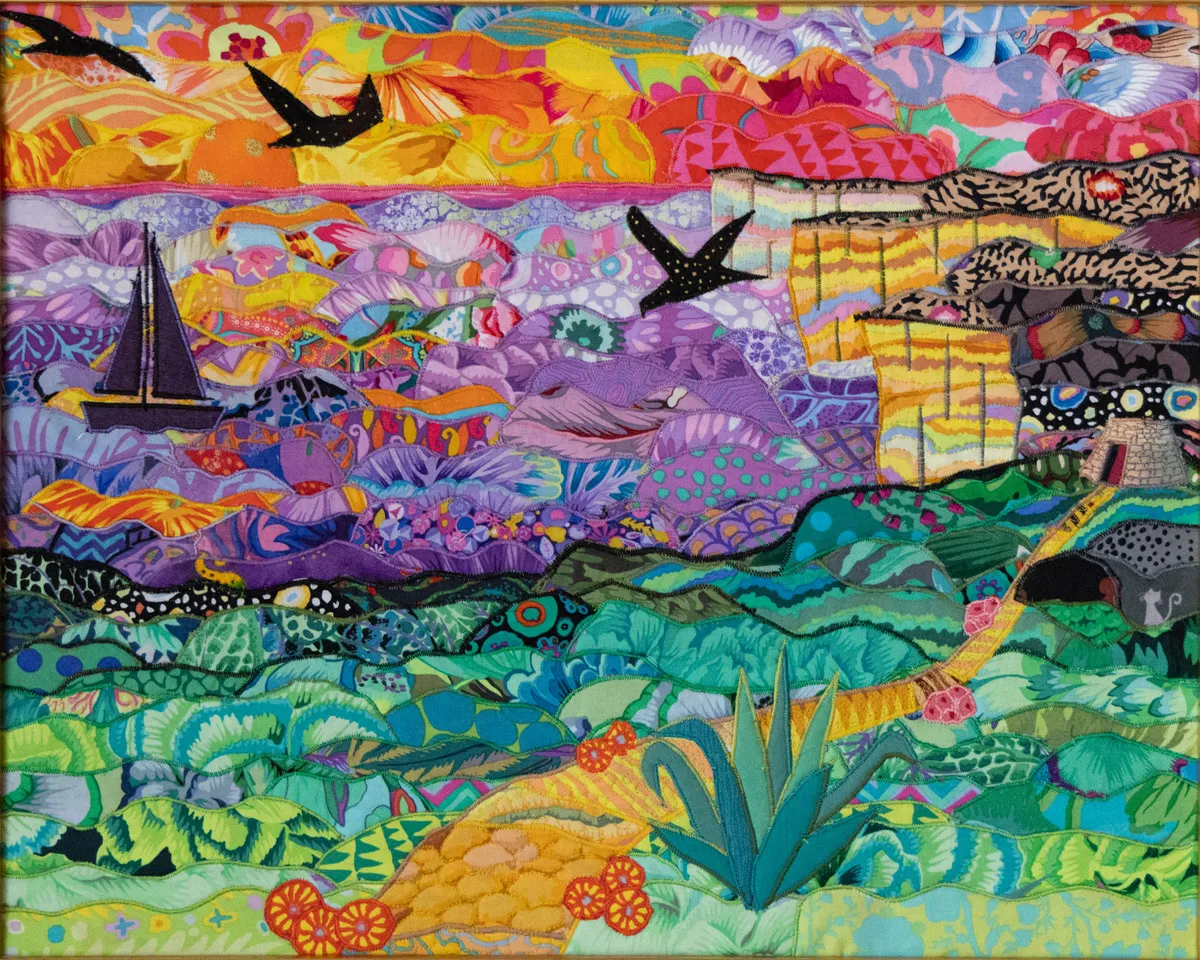 extile art by Anna Wright depicting the Ta' Ċenċ cliffs in Gozo, featuring an agave plant in the foreground and a sailing boat on a purple sea.