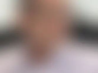 Professional portrait of Andrew Morley, a chartered building surveyor, wearing glasses and a light-colored button-down shirt.