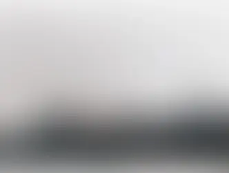  A black and white AI-generated image of Prime Minister Harold Wilson standing on a railway platform at Sheffield Pond Street Station in June 1970. He is wearing his iconic Gannex raincoat, holding a pipe in one hand and a briefcase in the other.