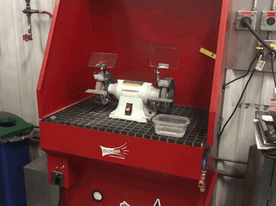 Close-up view of downdraft table perforated surface and control panel