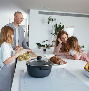 un père et une mère avec leurs deux anfants discutent calmement dans la cuisine