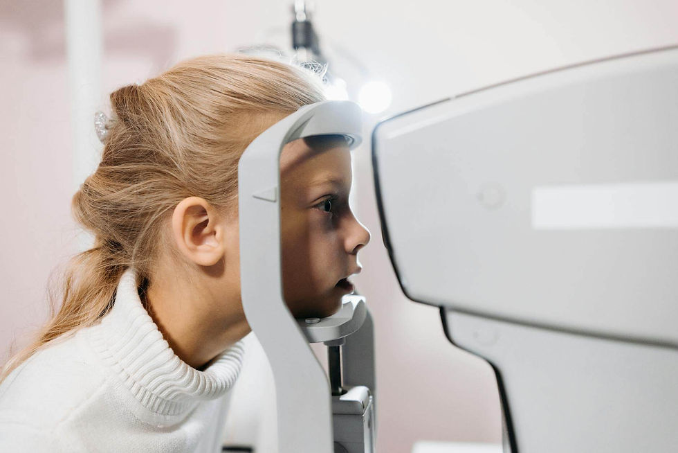 A young girl getting her vision tested using optometry equipment at a clinic.