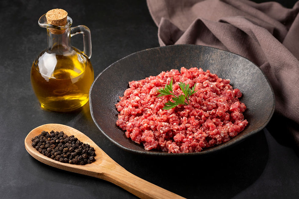 A dish with uncooked mince with parsley on it