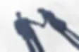 A couple’s shadow is seen while holding hands together.