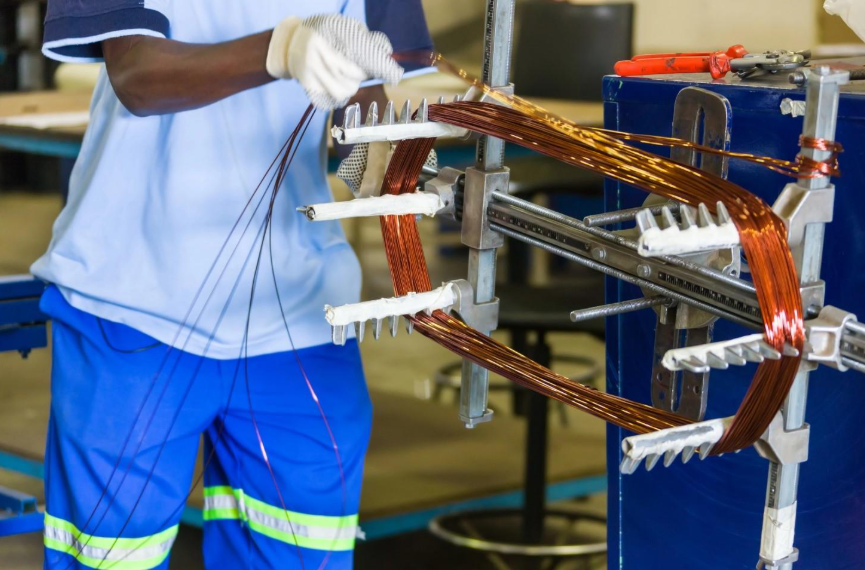 A repair technician rewinds an electric motor.