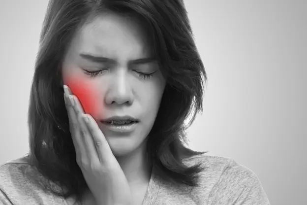 A woman suffers from dental pain.