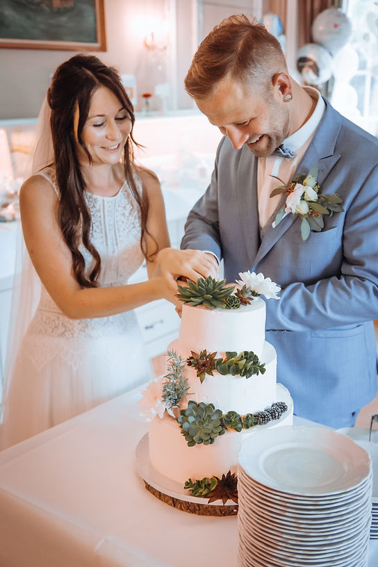 Brautpaar schneidet Hochzeitstorte an