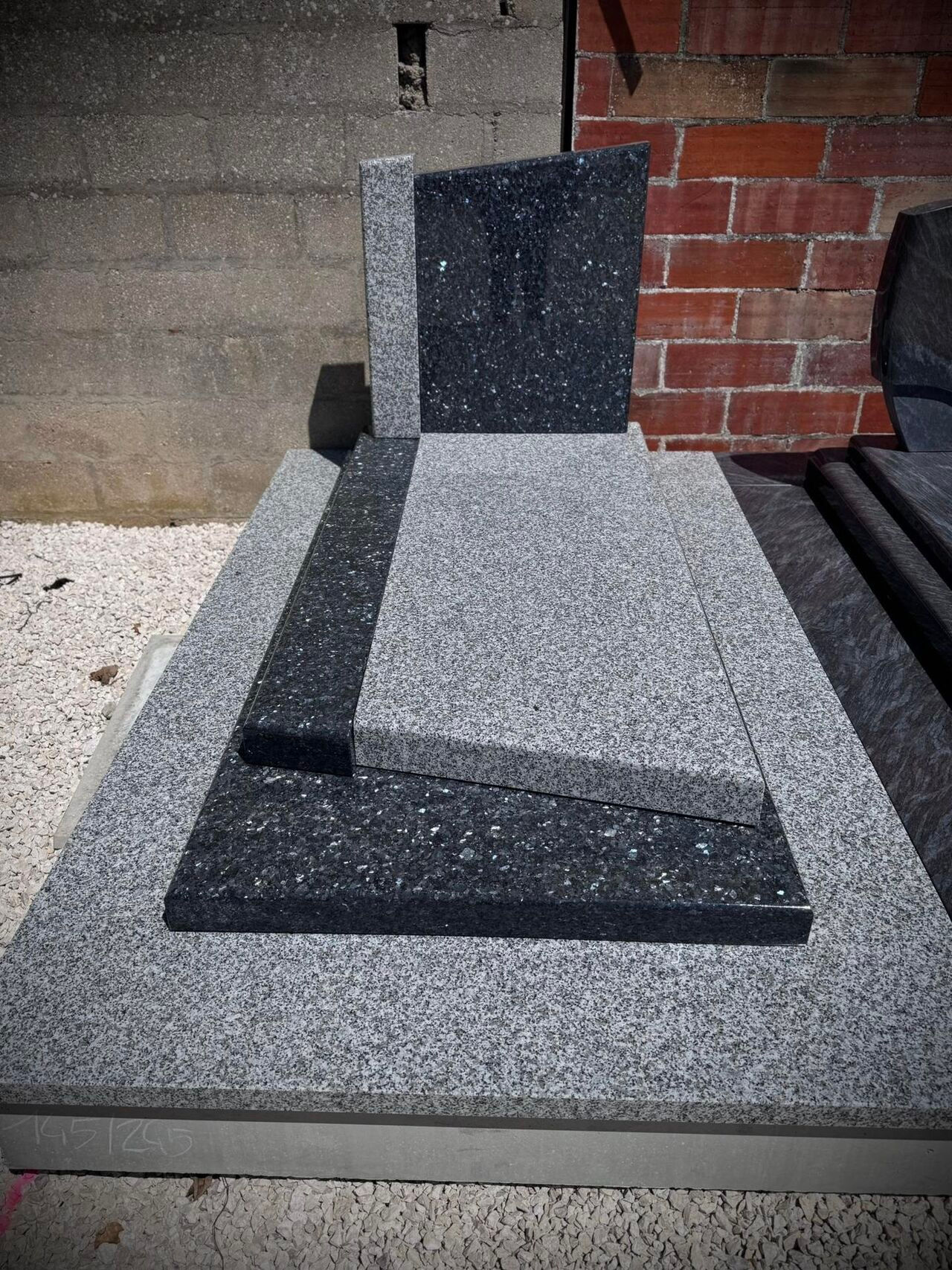 Monument funéraire bicolore, au style très moderne, gris clair et gris foncé, asymétrique,  très beau et visible à notre agence de Coulommiers