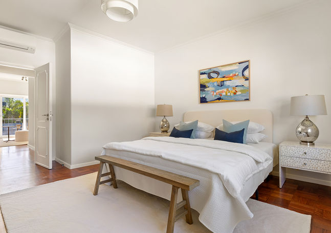 Master bedroom staging – elegant layered bedding and soft neutrals in mid-century villa
