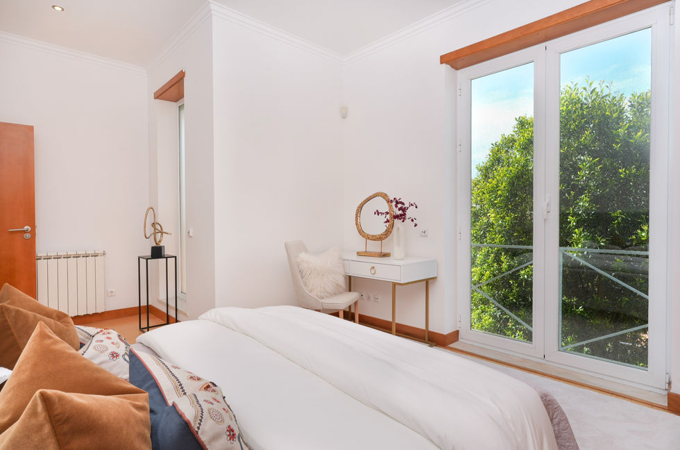 Elegant master bedroom in Quinta da Pedra, Cascais, showcasing a sophisticated mix of classic and modern pieces, creating a serene and inviting atmosphere