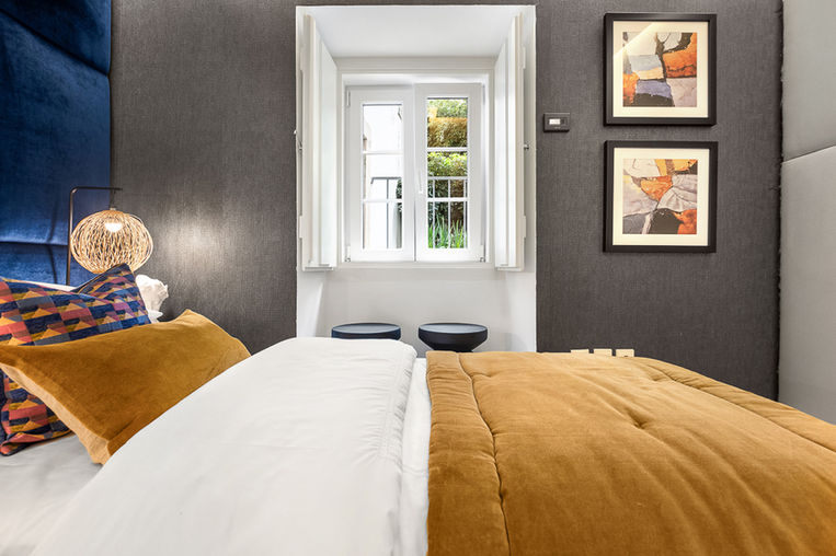 This staged bedroom in the Estoril villa features stylish, luxurious furnishings, including a plush bed and elegant decor that elevate the room’s sophistication. The walk-in closet is highlighted as a premium feature, enhancing the overall appeal of the space as a high-end retreat for potential buyers. Home Staging Portugal