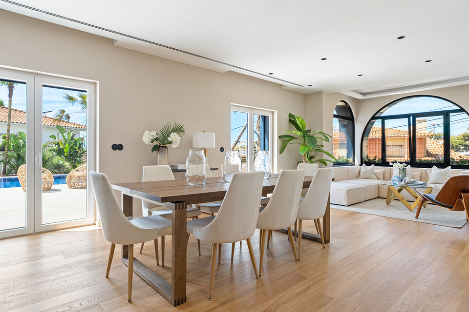 Staged dining room with walnut table and white upholstered chairs in Estoril blue ocean villa.
