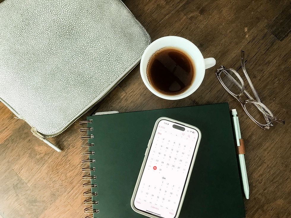 Laptop keyboard beside a latte with leaf foam art on a wooden table. The setting feels cozy and inviting, perfect for work or study.