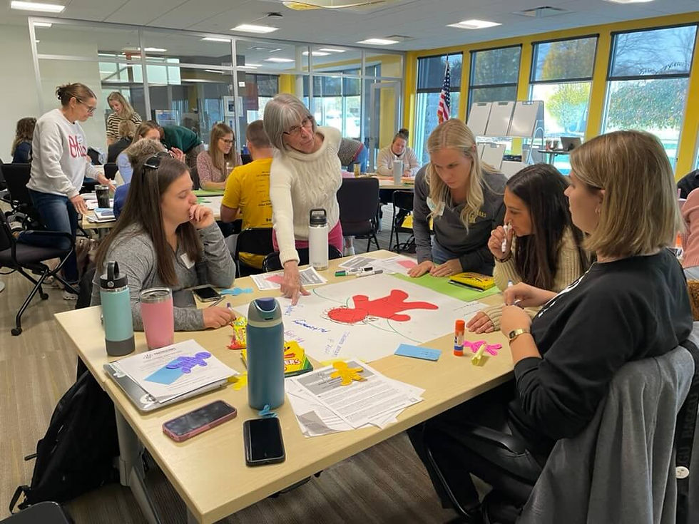 Group of educators collaborate around a table with visual aids.