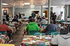 People seated and eating in a busy community dining hall