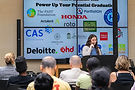 Woman speaking at event with PAST Foundation, Honda, Deloitte, and others.