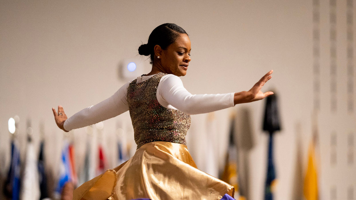 Woman in gold and purple dress gracefully dances
