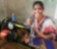 a woman smiling as she uses a sewing machine