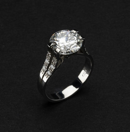 Anello di diamanti con grande diamante incastonato su sfondo nero, diamanti etici.