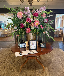 Large golden urn holding large floral arrangement in the venue entrance.