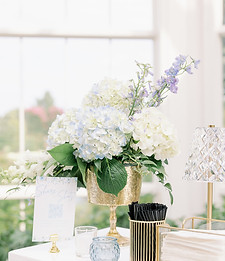Wedding bar decorated with white floral arrangements, greenery, and soft neutral wedding accents.