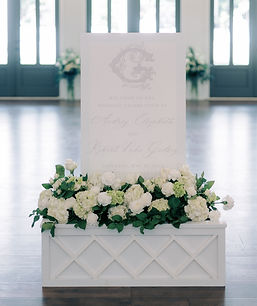 Welcome sign in floral box with elegant white florals.