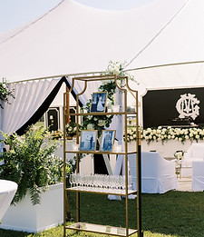 Champagne display decorated with greenery, white flowers, and wedding celebration decor.