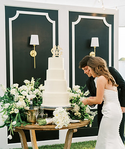 Large white petition walls with sconces displayed behind cake table.
