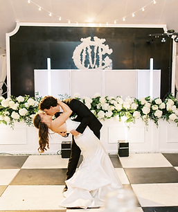 Custom event signage with white floral arrangements and greenery for a wedding or bridal shower display.