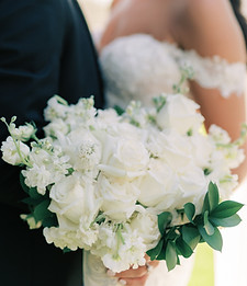 White bridal bouquet with soft greenery and neutral wedding flowers.