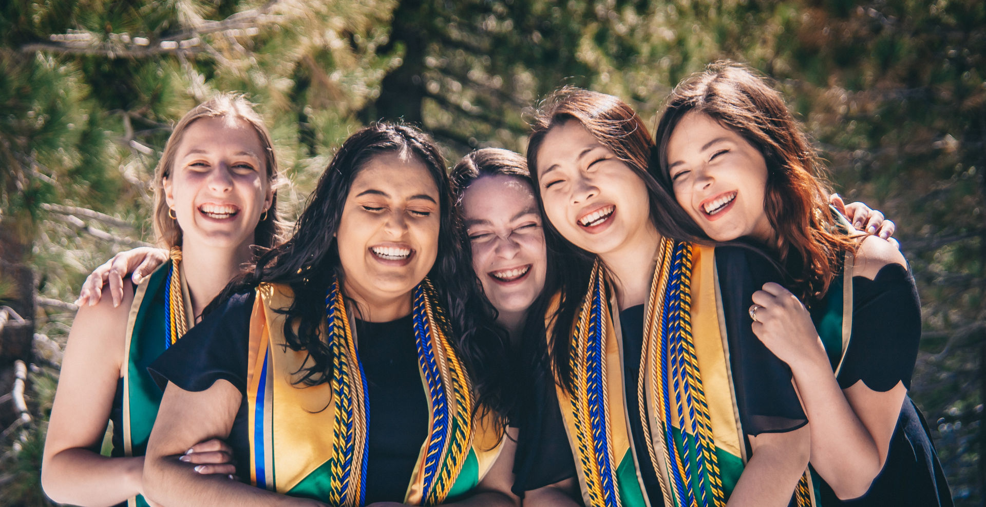 Group of friends pose together for graduation photos.