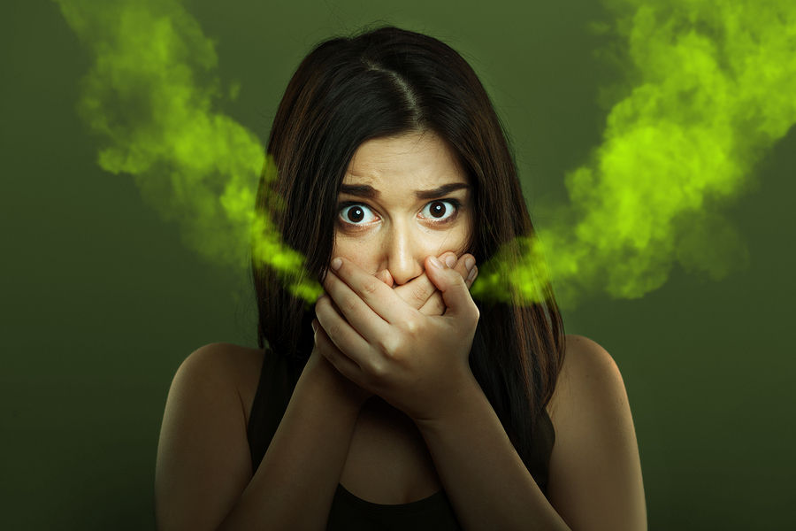Woman with bad breath covering her mouth with her hands