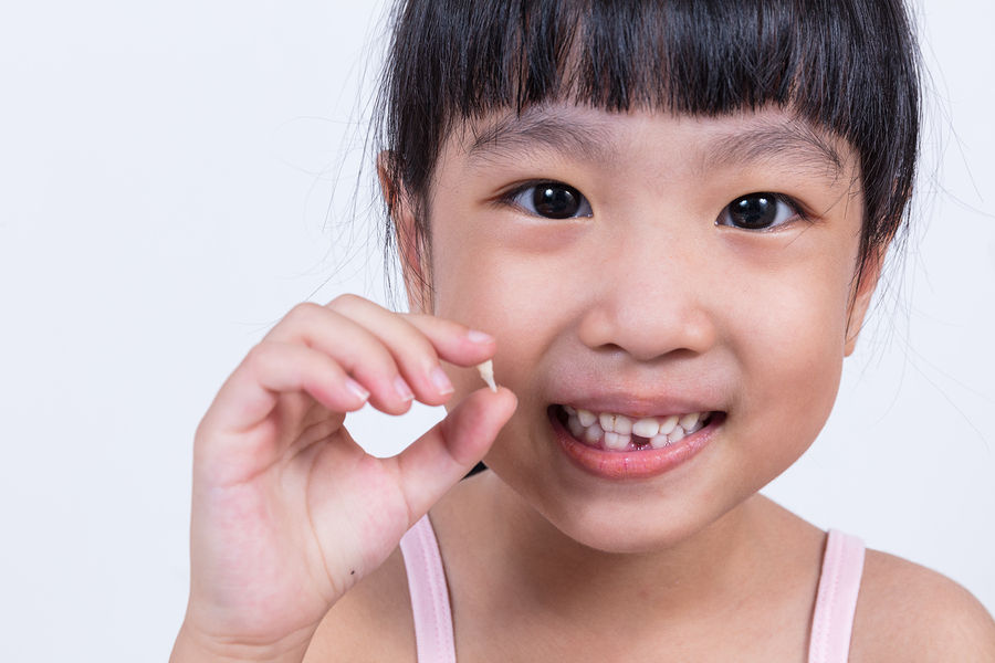 Little girl holding her missing tooth