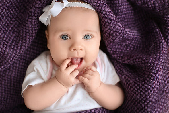 Cute little baby lying on plaid, teething