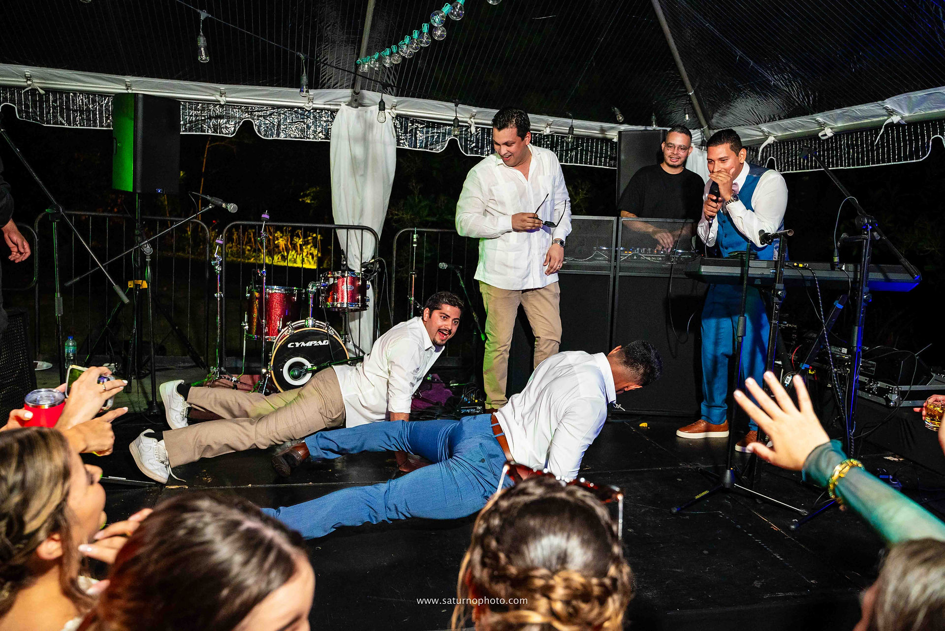 Dos contendientes se enfrentan haciendo pechadas en la tarima en un duelo hombre a hombre mientras los invitados los rodean y celebran durante la fiesta de boda en Casa Lourdes, El Valle de Antón. Fotografía por Ahmed Saturno.