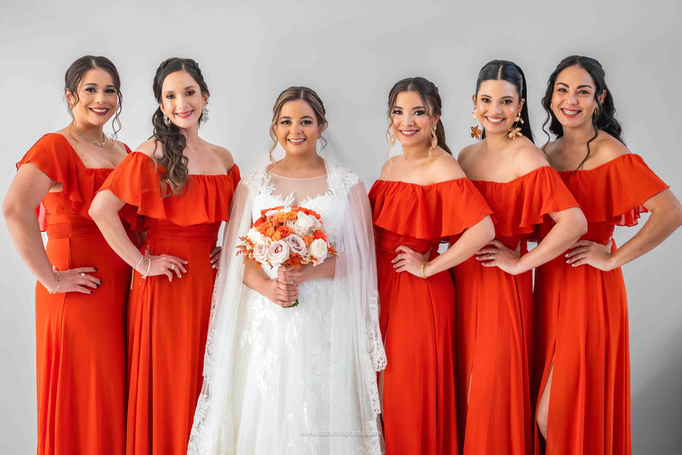 Retrato medium shot de la novia con sus cinco damas de honor en la casa de sus padres en El Valle de Antón, todas ya arregladas y posando juntas de forma elegante antes de salir hacia la iglesia para la ceremonia de boda. El Valle de Antón, Panamá. Fotografía por Ahmed Saturno.