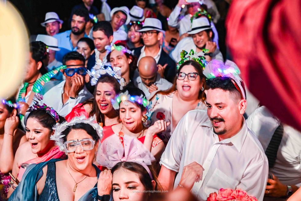 Invitados con disfraces de hora loca haciendo pasos de coreografía juntos en la pista de baile durante la fiesta de boda en Casa Lourdes, El Valle de Antón. Fotografía por Ahmed Saturno.