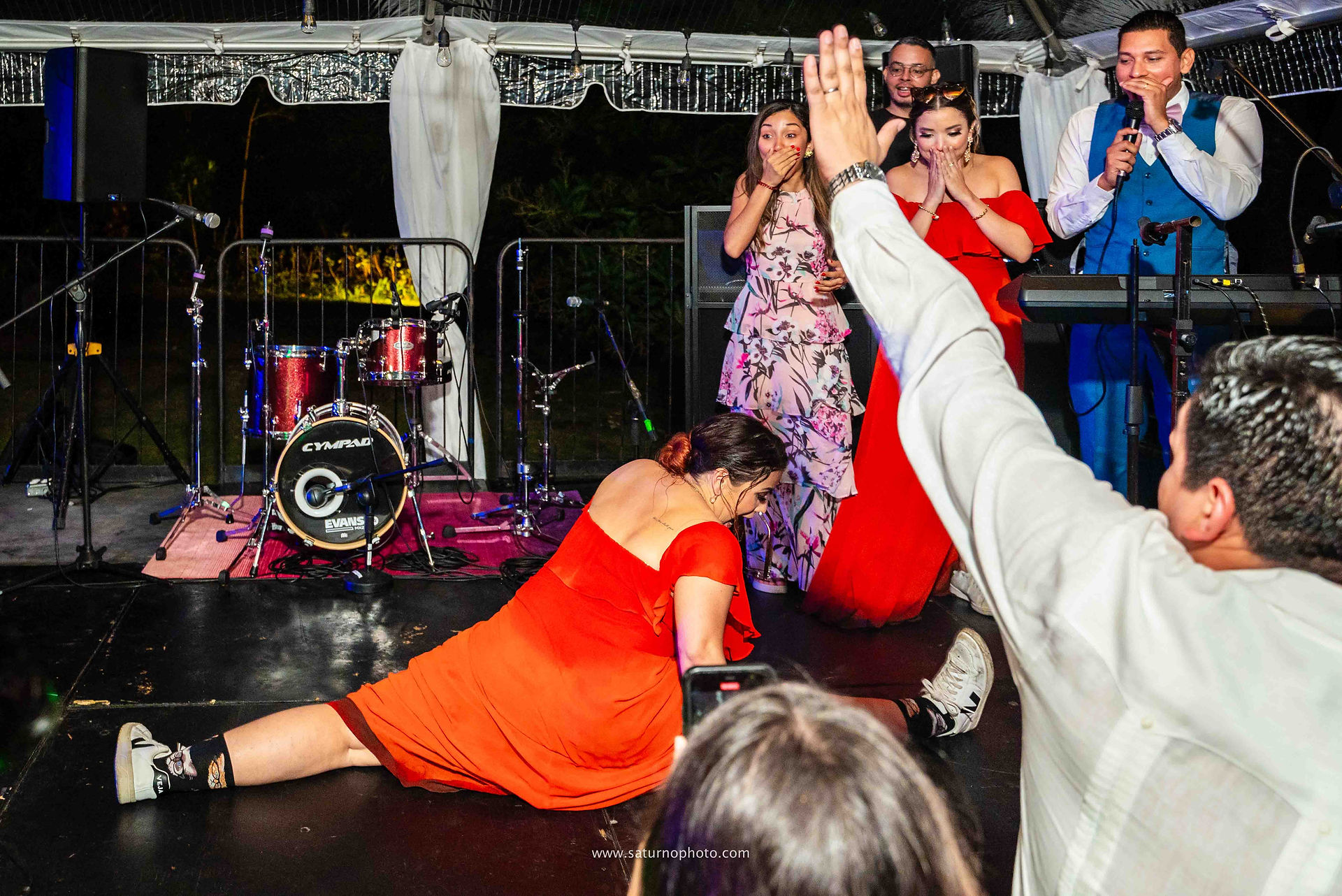 Invitada sorprende haciendo un split en la tarima durante la competencia de baile mientras todos los invitados quedan perplejos y sin poder creerlo en la fiesta de boda en Casa Lourdes, El Valle de Antón. Fotografía por Ahmed Saturno.