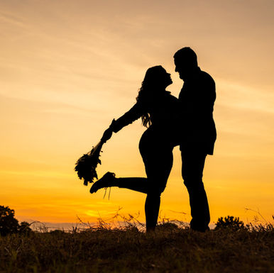 Fotografía pre bodas de novios a contraluz creando perfectas siluetas de ambos disfrutando un atardecer dorado, en Los Santos, Panamá. Fotografía por Ahmed Saturno