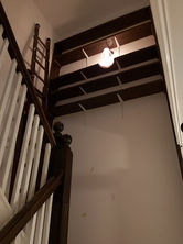 a staircase with a wooden railing and shelves